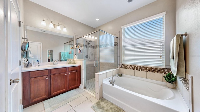 bathroom featuring shower with separate bathtub, vanity, and tile patterned floors