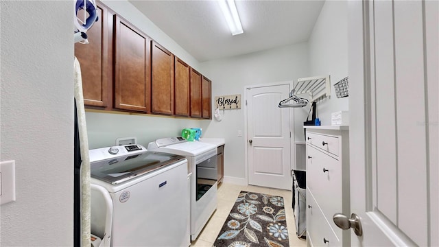 washroom with washer and dryer, cabinets, and light tile patterned flooring