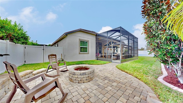 back of property with a lanai, an outdoor fire pit, a patio area, and a yard