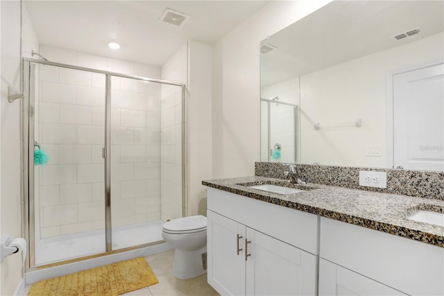 bathroom featuring tile patterned flooring, vanity, walk in shower, and toilet