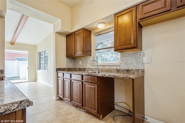 kitchen featuring decorative backsplash, sink, light tile patterned floors, and plenty of natural light