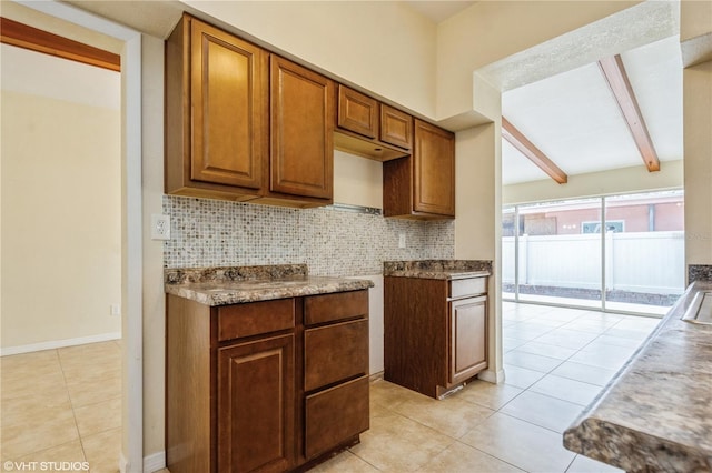 kitchen featuring beam ceiling, light tile patterned floors, and tasteful backsplash