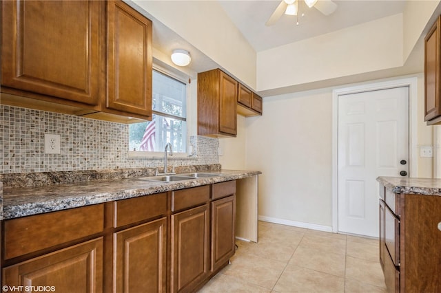 kitchen featuring ceiling fan, light tile patterned floors, sink, and tasteful backsplash