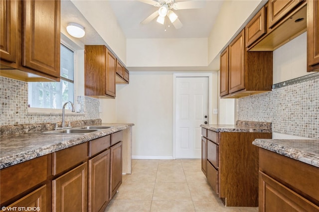 kitchen featuring ceiling fan, light tile patterned floors, sink, and tasteful backsplash