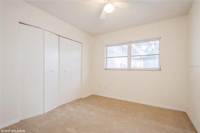 unfurnished bedroom featuring a closet, ceiling fan, and light colored carpet