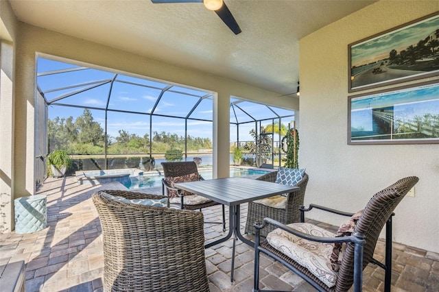 view of patio featuring glass enclosure and a swimming pool with hot tub