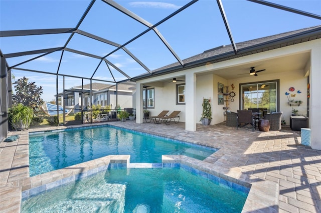 view of swimming pool featuring a patio area, ceiling fan, and glass enclosure