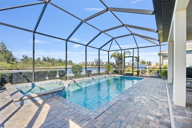 view of pool featuring glass enclosure, a patio area, a water view, and an in ground hot tub