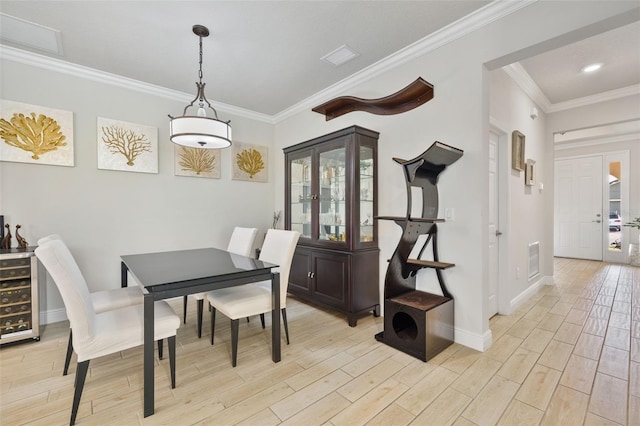 dining area featuring a wealth of natural light, ornamental molding, and beverage cooler