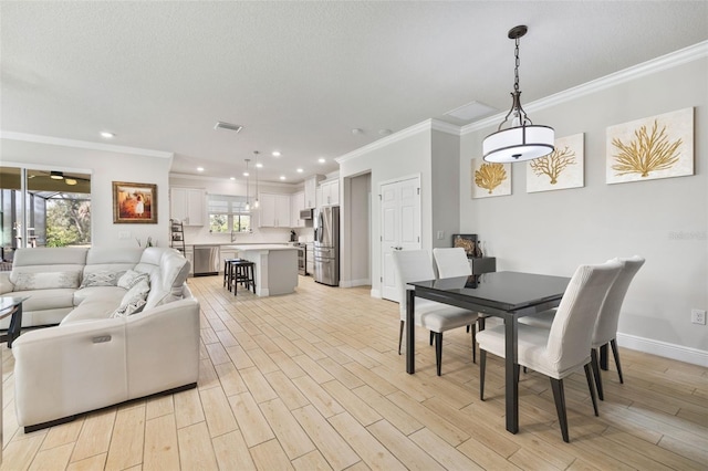 dining area featuring ornamental molding, light hardwood / wood-style flooring, and a healthy amount of sunlight