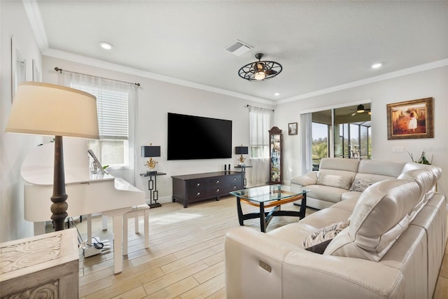 living room featuring a wealth of natural light, ceiling fan, and ornamental molding