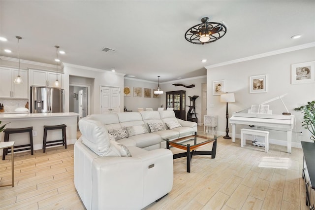 living room with ceiling fan and ornamental molding