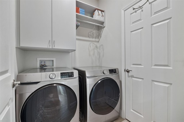 washroom featuring cabinets and separate washer and dryer