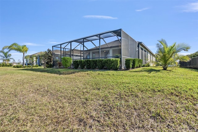 back of property with glass enclosure and a yard