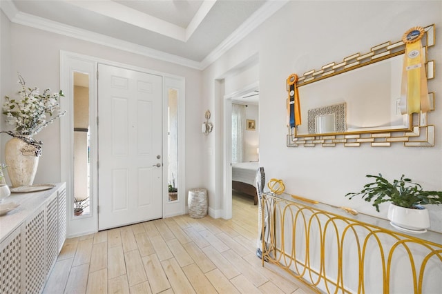 entrance foyer with ornamental molding and light hardwood / wood-style floors