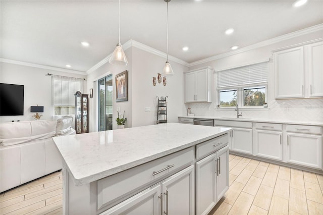 kitchen with sink, white cabinetry, tasteful backsplash, a center island, and hanging light fixtures