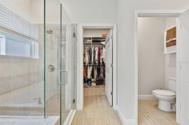 bathroom featuring hardwood / wood-style flooring, toilet, and walk in shower