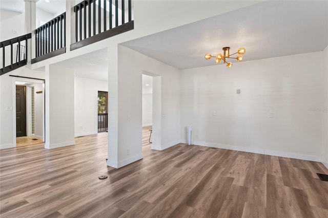 interior space with hardwood / wood-style flooring, a high ceiling, and a notable chandelier