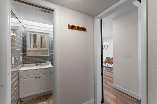 bathroom featuring vanity, wood-type flooring, and backsplash