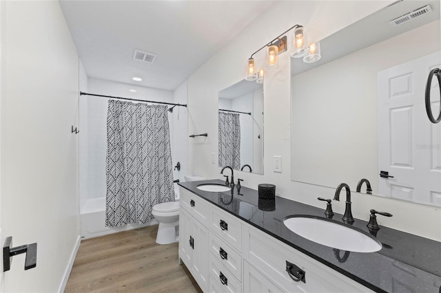 full bathroom with shower / tub combo with curtain, vanity, hardwood / wood-style flooring, and toilet