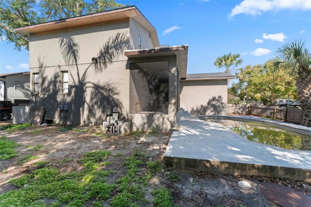 back of property featuring a fenced in pool