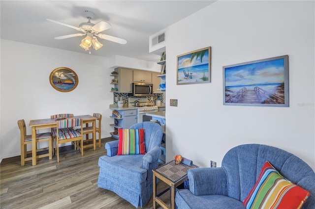 living area with ceiling fan and light hardwood / wood-style flooring