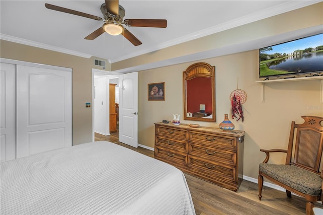 8174 Terrace Garden Dr N Unit 110, Saint Petersburg, FL 33709 - bedroom featuring wood finished floors, ornamental molding, a closet, and ceiling fan