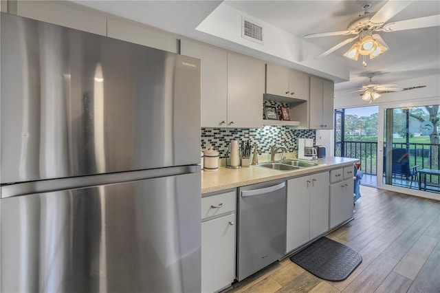 8174 Terrace Garden Dr N Unit 110, Saint Petersburg, FL 33709 - kitchen featuring appliances with stainless steel finishes, light countertops, decorative backsplash, a ceiling fan, and light wood finished floors