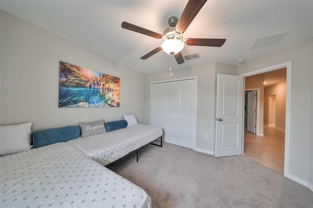 carpeted bedroom with a closet and ceiling fan