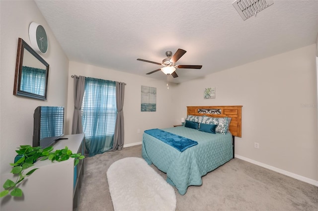 carpeted bedroom with ceiling fan and a textured ceiling