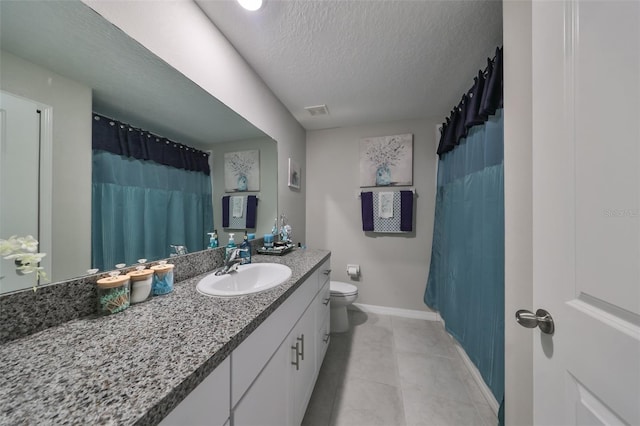 bathroom featuring a textured ceiling, vanity, toilet, and tile patterned floors