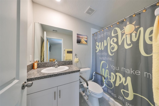 bathroom featuring vanity, a textured ceiling, and toilet