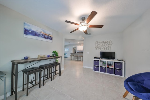 living room with ceiling fan and light tile patterned flooring