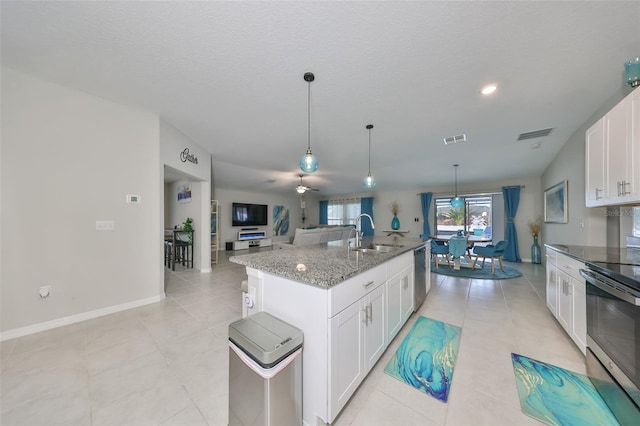 kitchen with stainless steel appliances, sink, decorative light fixtures, a center island with sink, and white cabinets