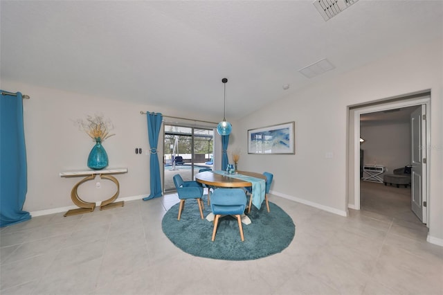 dining area with light tile patterned floors and vaulted ceiling