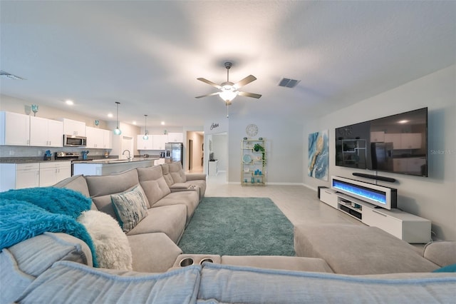 living room featuring ceiling fan and sink