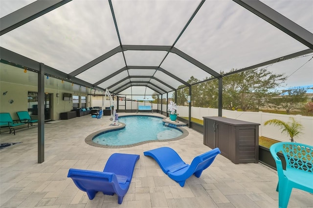 view of pool with glass enclosure and a patio area