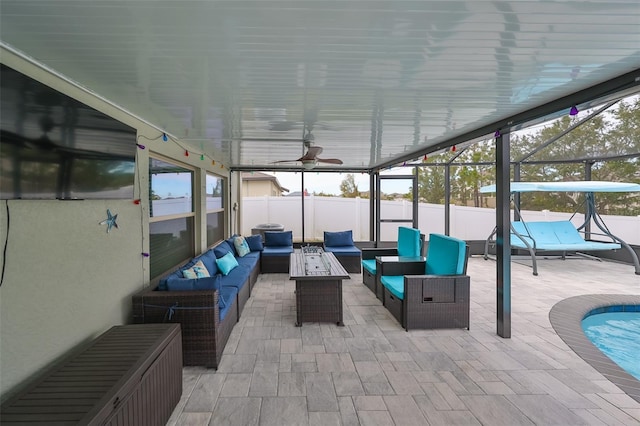 view of patio / terrace with glass enclosure, an outdoor living space with a fire pit, and ceiling fan