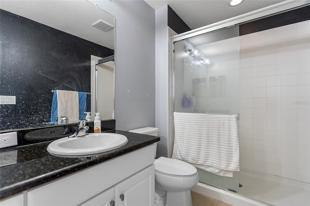 bathroom with toilet, an enclosed shower, and a textured ceiling