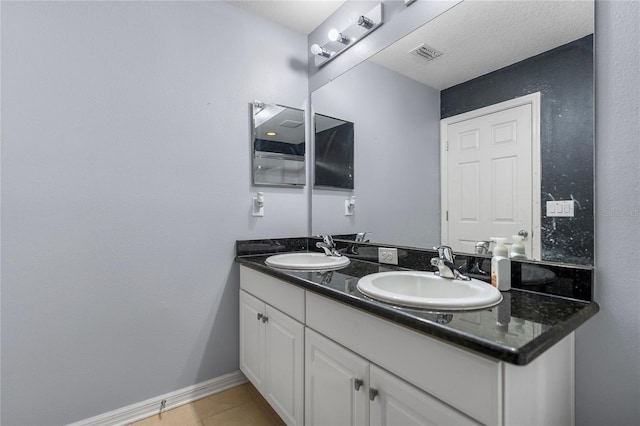 bathroom featuring tile patterned flooring, vanity, and a textured ceiling