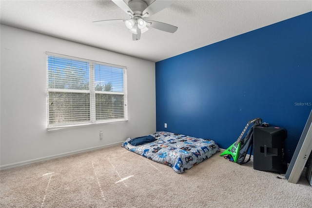 carpeted bedroom with ceiling fan and a textured ceiling