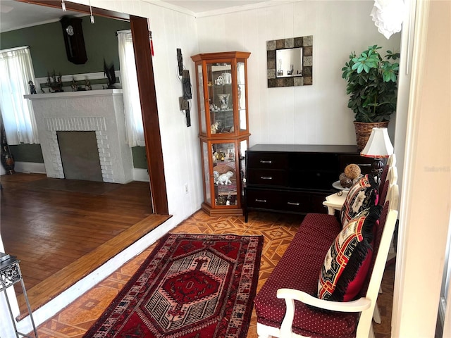 living room featuring a brick fireplace and crown molding