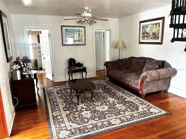 living room featuring ceiling fan, wood-type flooring, and ornamental molding