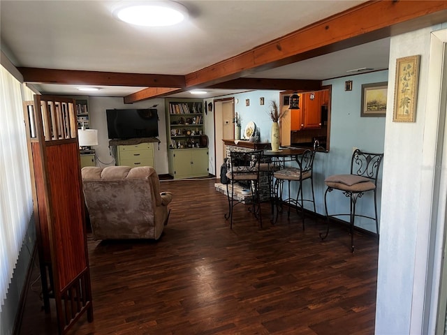 living room with built in shelves, beam ceiling, and dark hardwood / wood-style flooring