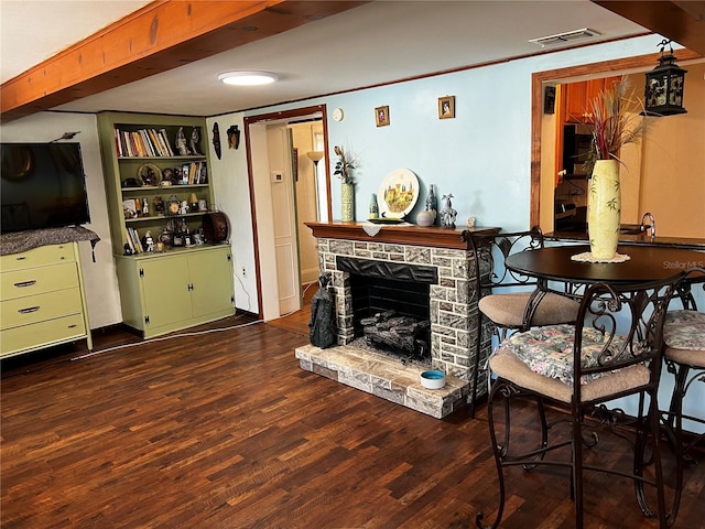 living room with built in features, a fireplace, and dark wood-type flooring