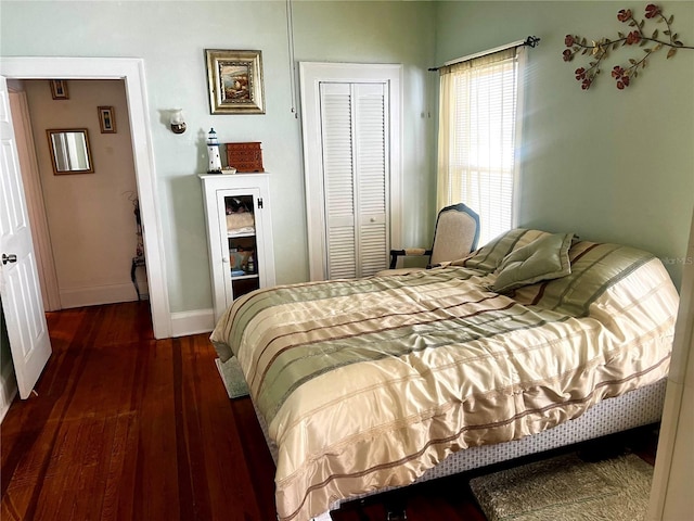 bedroom with dark hardwood / wood-style floors and a closet