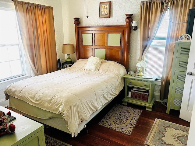 bedroom featuring multiple windows and dark hardwood / wood-style floors