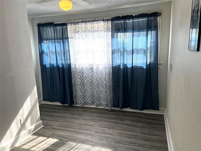 empty room with ceiling fan, crown molding, wood-type flooring, and a textured ceiling