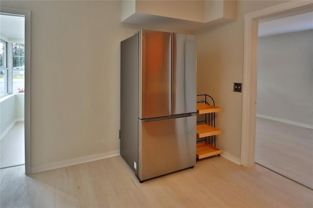 kitchen featuring stainless steel fridge, butcher block countertops, and light hardwood / wood-style flooring