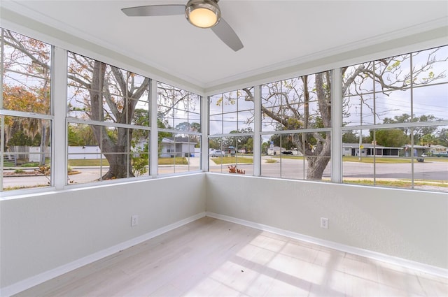 unfurnished sunroom featuring ceiling fan